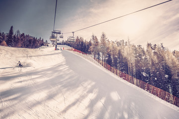 Sunny day on steep ski slope, winter landscape. Vintage filter