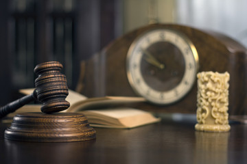 Law theme, mallet of the judge, court gavel wooden rustic desk, handcuffs, candle and books