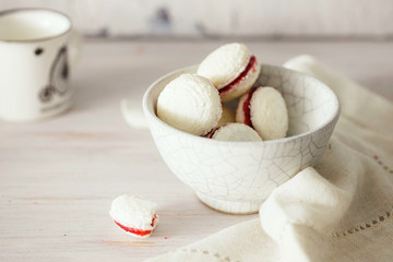 Gluten-free coconut macarons - delicate French cookies with strawberry filling. Close up, shallow depth of field, copy space.