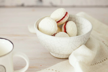 Gluten-free coconut macarons - delicate French cookies with strawberry filling. Close up, shallow depth of field, copy space.