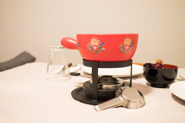 Red Swiss fondue pot on a table