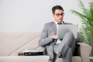 Businessman with laptop notebook sitting in sofa