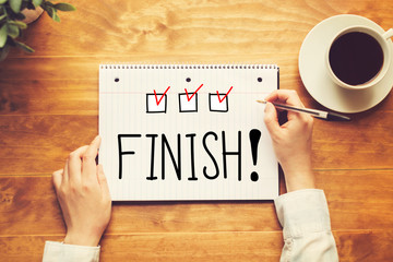 Finish text with a person holding a pen