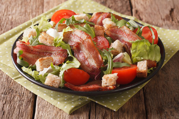 Mix salad of fried bacon, tomato, croutons and lettuce close-up. horizontal