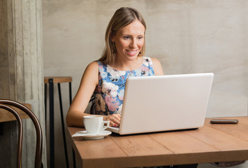 Young  woman working on her laptop in cafe