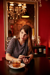 Pretty young lady texting at table