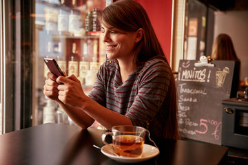 Smiling young lady sitting in a pub