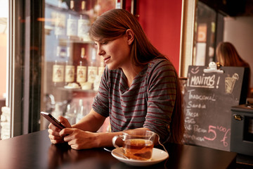 Pensive young lady sitting in a bar