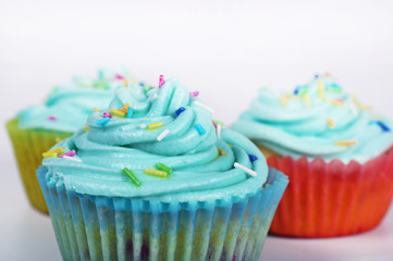 Vanilla cupcakes with colorful icing on white background