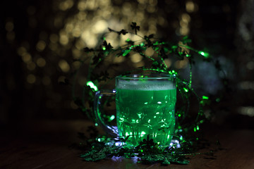 St patricks day. St. Patricks Day decoations with green beer. Irish green beer, traditional alcohol for St. Patrick's day holiday celebration. Glass of green beer with clover leaves on wooden table.