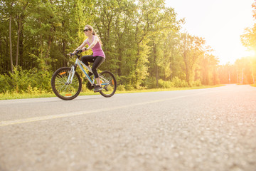 Fototapeta na wymiar Girl on mountain bike rides on the trail on a beautiful sunrise.