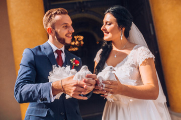 Wedding pigeons in hands of the groom and the bride near church