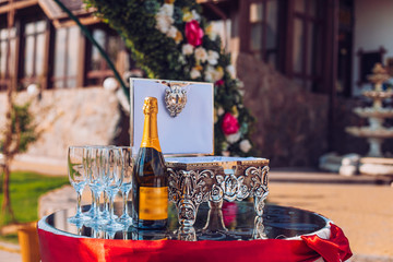 bottle of champagne and glasses on the table with box for gifts. Festive table. Outdoor.