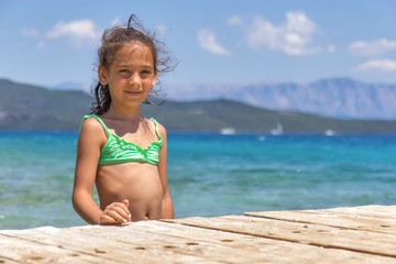 Girl on the wooden pier in the sea