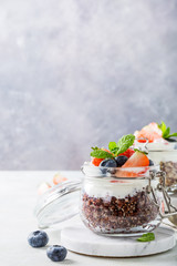 Quinoa with yogurt and berries in glass jar. Healthy gluten free breakfast concept with copy space.