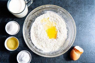 Cooking pancakes. Delicious savory pancakes. Kitchen table. Crumble flour, eggs and milk.