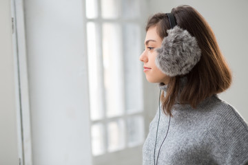 Teen girl in fluffy earphones listen music