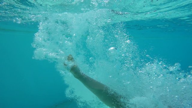 Girl jumping in swimming pool, underwater slow motion