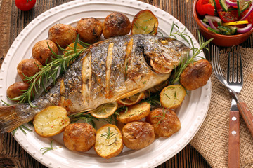Grilled fish with roasted potatoes and vegetables on the plate