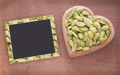 Pumpkin seeds on the wooden background