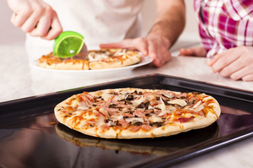 Couple having fun in the kitchen while making pizza