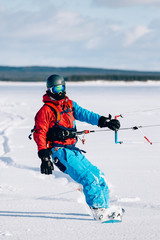 Fototapeta na wymiar Snowkiting. Male athlete snowboarder rides a kite skiing on a frozen lake. The Kola Peninsula. kiting. Snowkite