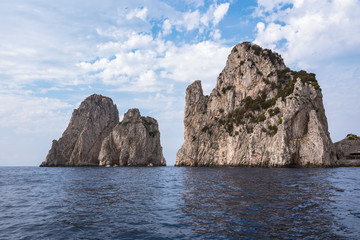 Fototapeta na wymiar Cliff coast of Capri Island with famous Faragioni rocks