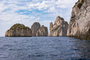 Fototapeta na wymiar Cliff coast of Capri Island with famous Faragioni rocks
