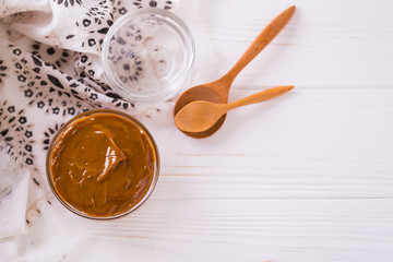 Bowl of homemade melted caramel sauce on wooden table