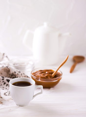 Fototapeta na wymiar Bowl of homemade melted caramel sauce and coffee