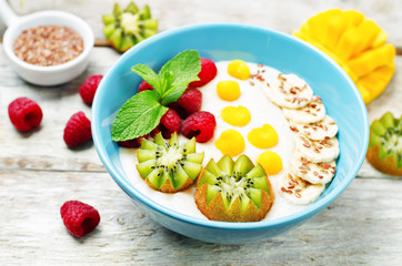 Breakfast oatmeal porridge with kiwi, mango, raspberry, banana and flax seeds
