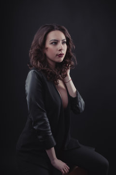 Fashionable brunette woman with curly hair wearing leather jacket