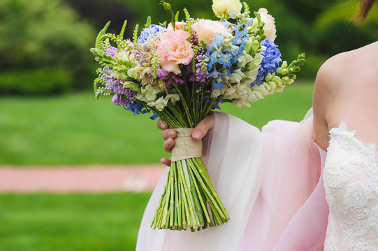 Wedding bouquet of flowers in hands of young bride