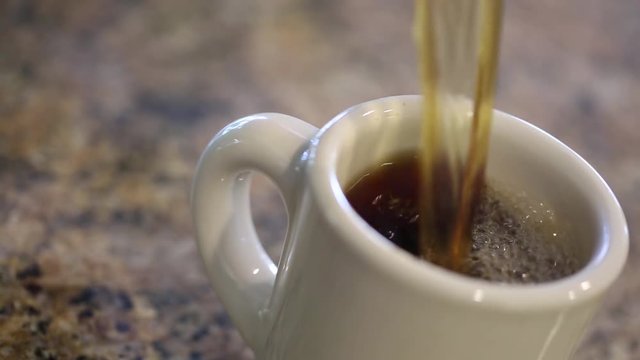 Woman Making Fresh Coffee in Her Kitchen - Part 3 of 3. Complete set contains HD video clips of woman pouring coffee grounds and water into coffee maker and finally brewed coffee into cup.
