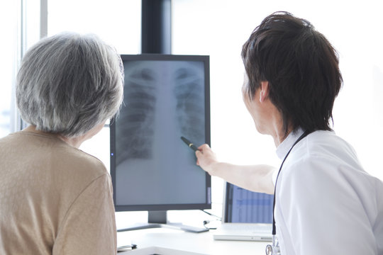 Doctor Looking at X-Ray with Senior Woman