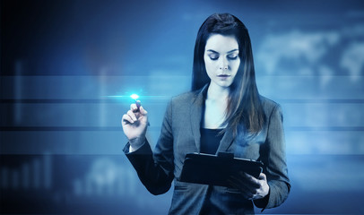 Portrait d'une jeune femme d'affaires écrivant sur un tableau tactile, une tablette dans sa main