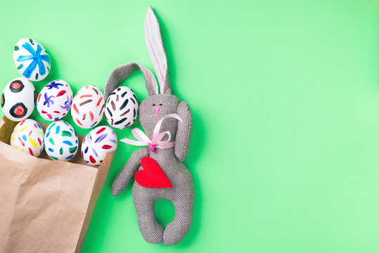 Easter eggs in a paper bag. Green background. Easter bunny. Rabbit. Easter ideas. Easter eggs. Space for text.