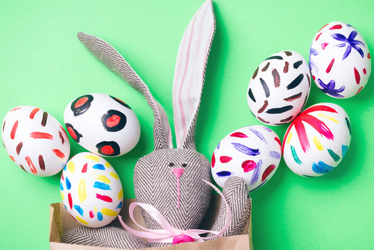Easter eggs in a paper bag. Green background. Easter bunny. Rabbit. Easter ideas. Easter eggs. Space for text.
