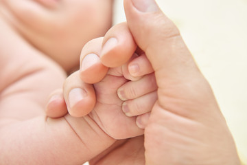 Fototapeta na wymiar A parent holding the hand of a newborn baby