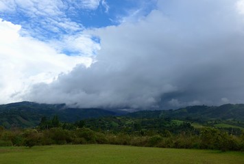 Large storm clouds rolling in across the field over the hills around San Agustin, southern Colombia.