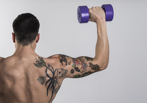 Brazo masculino fuerte muestra b&iacute;ceps y tatuajes