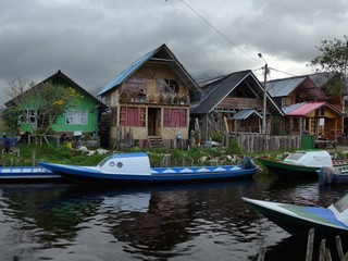 Fototapeta na wymiar Colorful houses and boats on a small canal of a fresh water lake in Colombia