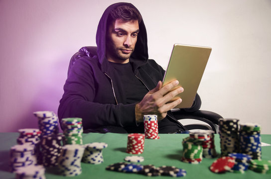 Poker player playing online via tablet at home/poker addiction 