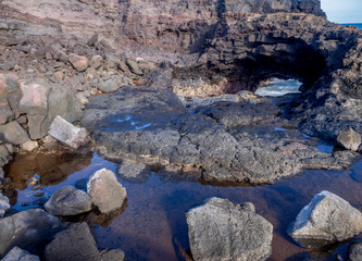 Lava rock off stunning glass beach near Port Allen town on Kauai Hawaii.