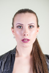 Beautiful woman in black leather jacket, studio shot light background