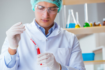 Young doctor working on blood test in lab hospital