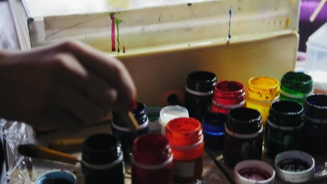 Process of painting - colourful paint drops on the purple circles - woman draws on water in Liquid Ebru art technics