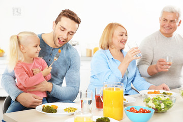 Obraz na płótnie Canvas Happy family having lunch in kitchen