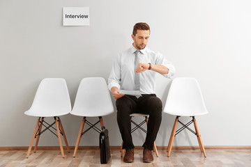 Fototapeta premium Young man waiting for interview indoors