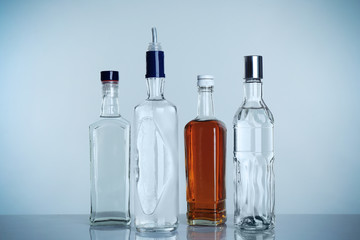 Table with different bottles of wine and spirits on light background